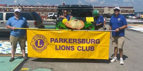 Lion members holding a Parkersburg Lions Club banner before a parade