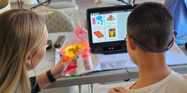 Child using a dynavox eye gaze AAC system in a speech therapy session.