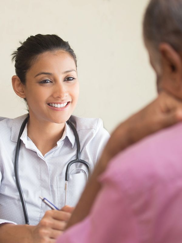 Smiling female doctor consulting with an elderly patient.