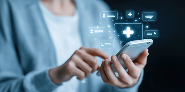 Person using a smartphone with digital health icons floating above it.