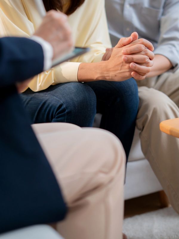 Couple holding hands during a counseling session.