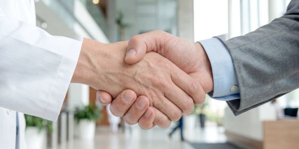 Close-up of a handshake between two professionals in a modern office.