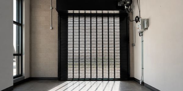 Empty industrial garage with metal grid door.