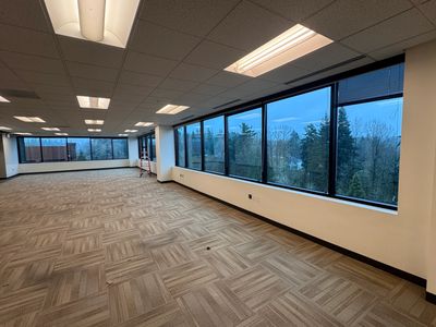 Empty office space with large windows and carpeted floor in Lake Oswego