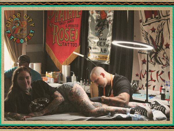 Tattoo artist working on a tattooed woman at Cigar City Tattoo Fest.
