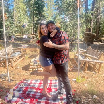 Marriage proposal with printed Polaroids, string lights, and rose petals in duck creek Utah