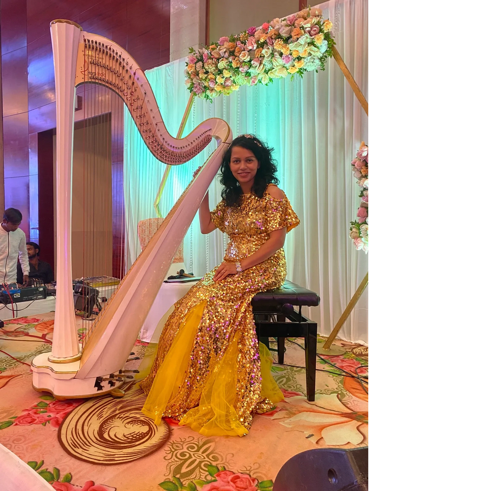 Man sitting outdoors with a hat and ukulele on a backpack beside him.
