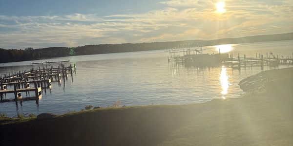 Sunset over a calm lake with docks extending into the water.