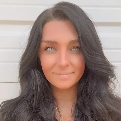 Portrait of a woman with long dark hair and piercing light eyes.