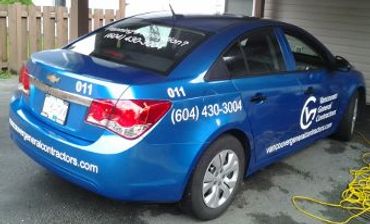 Blue Chevrolet sedan with company advertising.