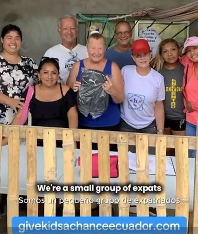Group of diverse expats smiling behind a wooden fence with a backpack.