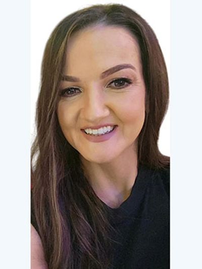 A woman with long brown hair smiling at the camera.
