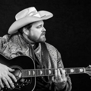 Man in cowboy hat playing guitar.