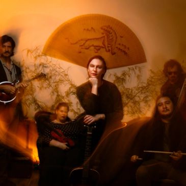 Group of five musicians with warm, artistic lighting