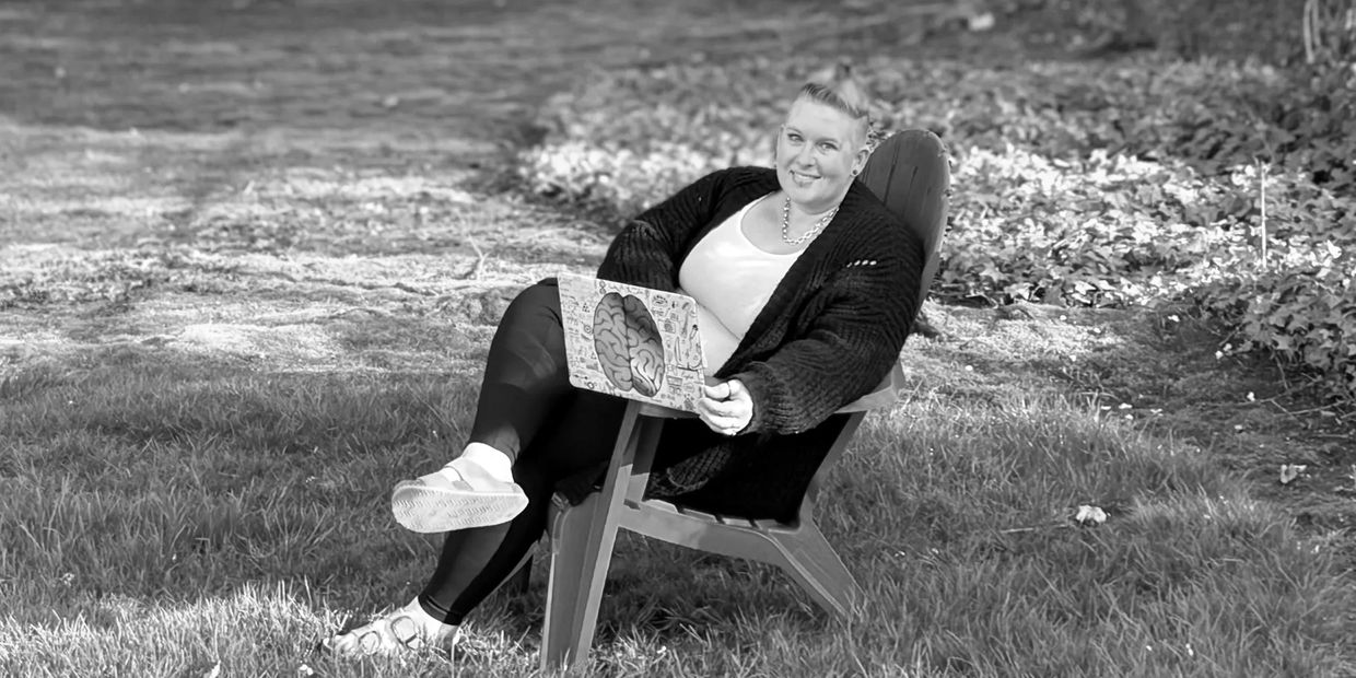 Woman sitting on a chair outside with a laptop.