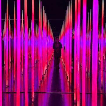 Neon-lit corridor with vertical light bars and mirrored walls.