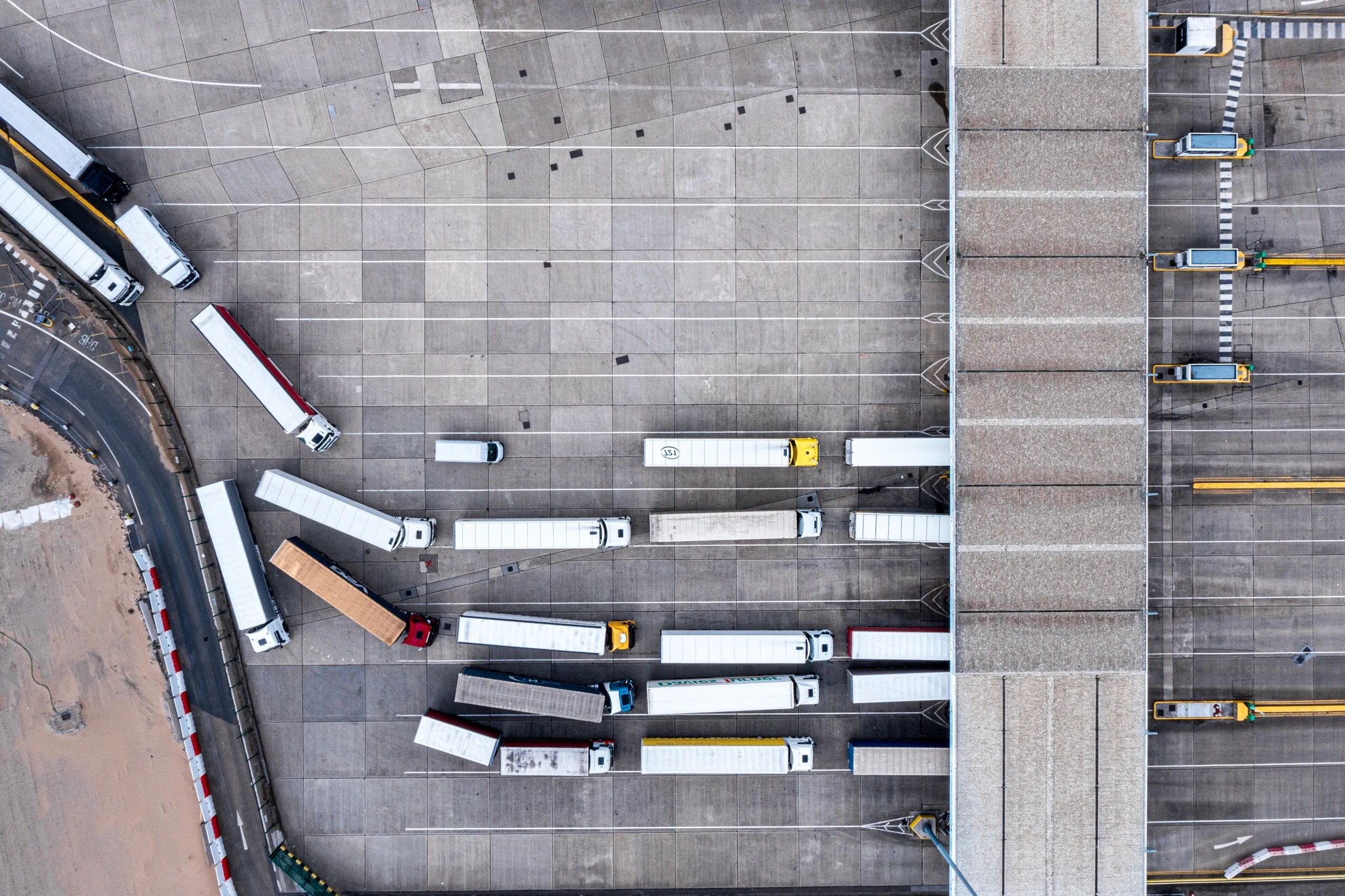 Aerial view of trucks lined up at a large warehouse loading area.