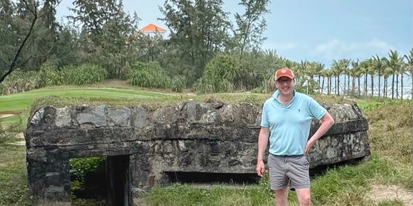 Will Nuckols standing next to an old pillbox at Danang Golf Club in Vietnam