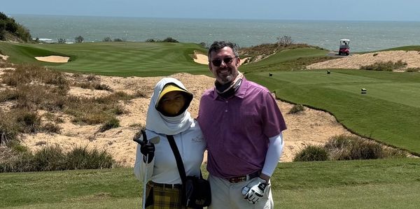 Jay Rooke standing with his caddy at the Bluffs Ho Tram golf course in Vietnam