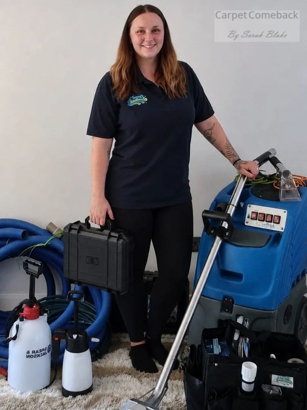 Woman standing with carpet cleaning equipment and tools.