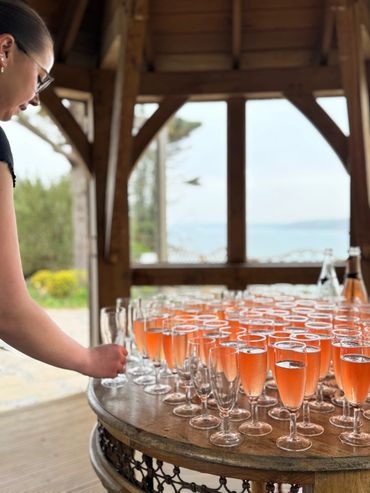 Glasses of sparking rosé arranged by Ad Hoc Catering for an outdoor wedding in Devon