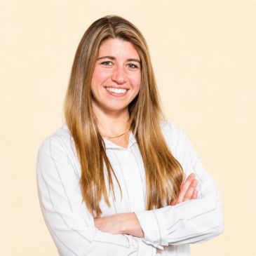 Smiling woman with long hair in a white shirt.