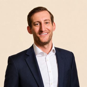 Professional man smiling in suit jacket.