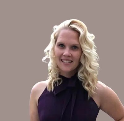 Smiling woman with curly blonde hair in a dark purple dress.