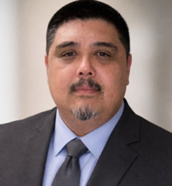 Professional man in suit and tie with neutral background.