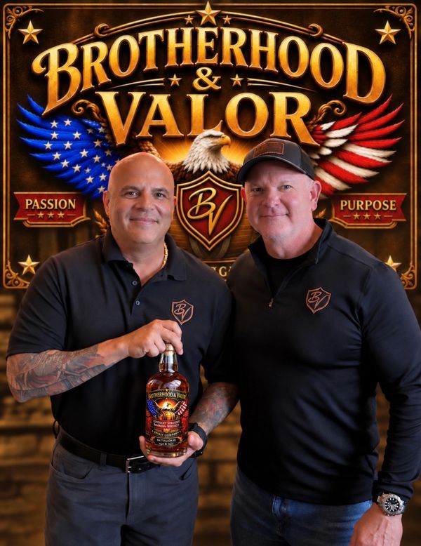 Two men holding a Brotherhood &amp; Valor bottle in front of a branded backdrop.