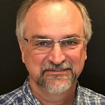 Smiling middle-aged man with glasses and a beard.