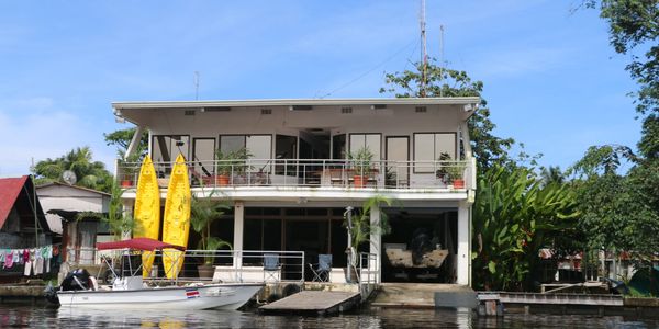 Vista desde la laguna de las instalaciones de Tortuguero Adventures, Casa de dos pisos blanca