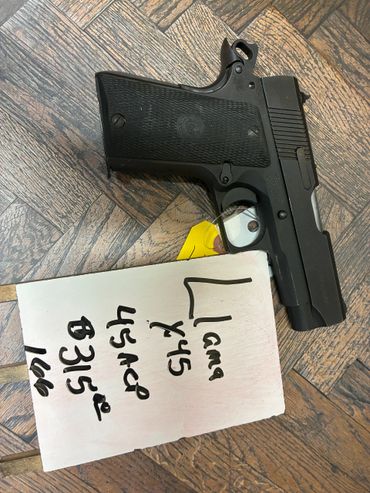 Black semi-automatic pistol with a note listing calibers and price.