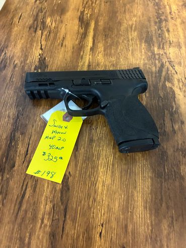 Smith &amp; Wesson M&amp;P 2.0 .40 caliber handgun with price tag on wooden surface.