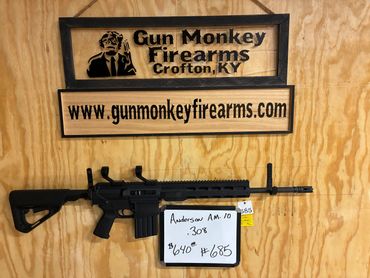 Assault rifle displayed with Gun Monkey Firearms signage in Crofton, KY.