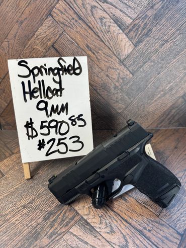 Springfield Hellcat 9mm handgun displayed with price signs.