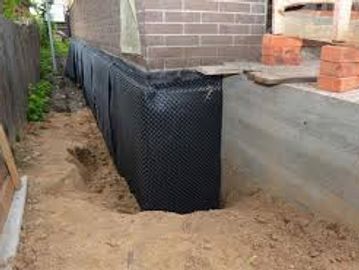Waterproofing membrane applied to a building foundation.