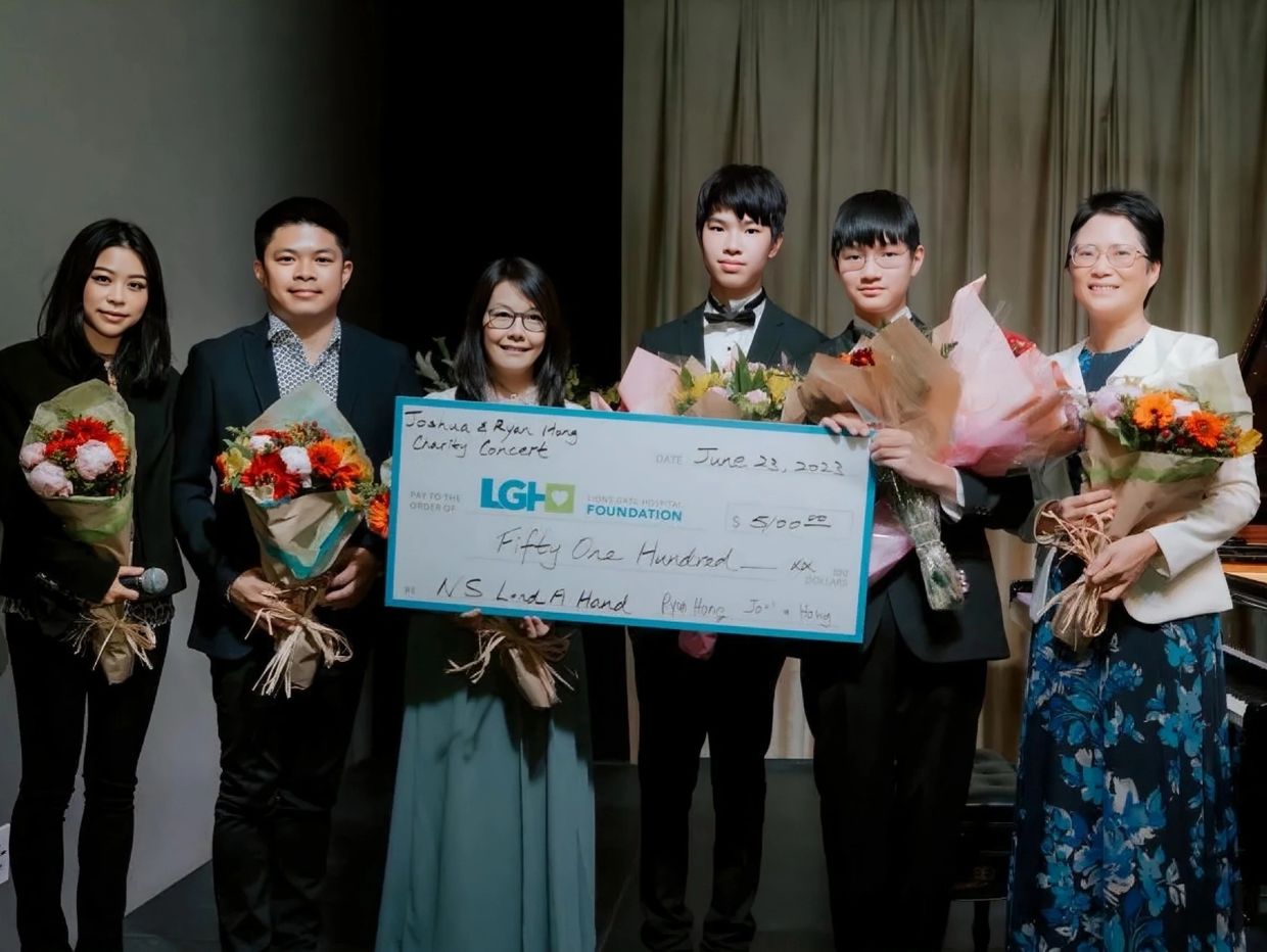 Group holding flowers and a large charity check for LGH Foundation.