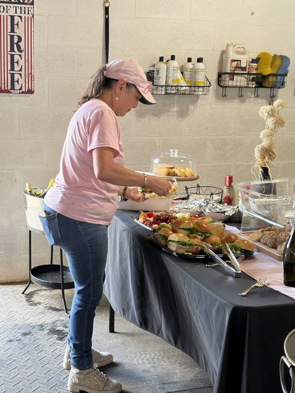 Woman serving herself from a buffet table.