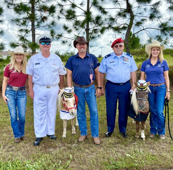 Group photo with two mini ponies in military hats and uniforms