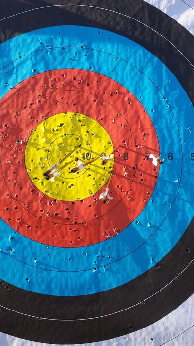 A large archery target with people standing on it, viewed from above.