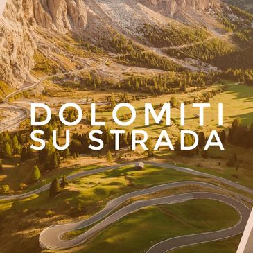Winding mountain road in the Dolomites with text overlay.