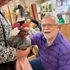 Senior finds joy petting a chicken at Intergenerational Daycare in Tigard, OR.