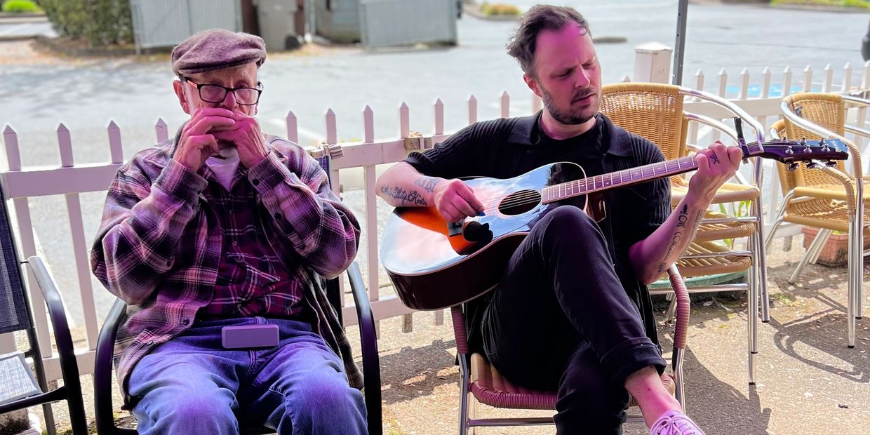 Senior Care Director and elder playing music together at Daycare in Tigard, OR.