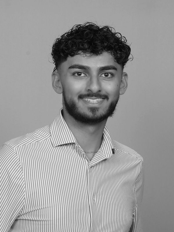 Young man in striped shirt smiling at the camera.