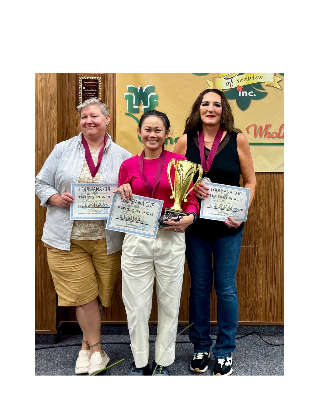 three women with certificates and trophy 