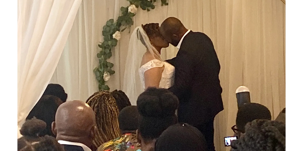 a bride and groom kissing during their wedding ceremony