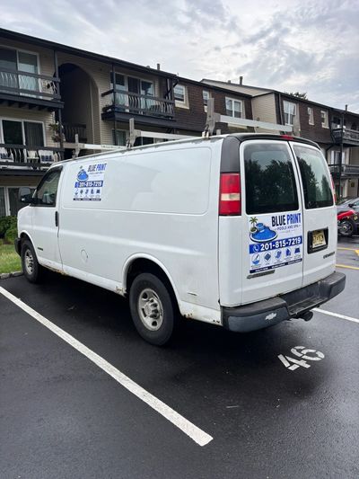 White service van parked outside apartment complex.