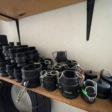 Varias piezas de acoplamiento negro apiladas en una estantería de madera.