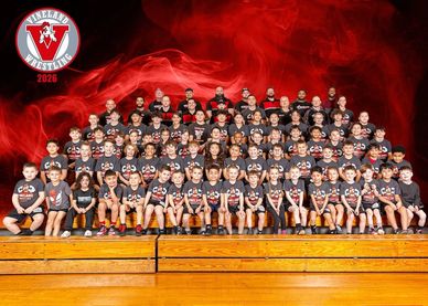 Large group photo of a wrestling team in matching shirts.